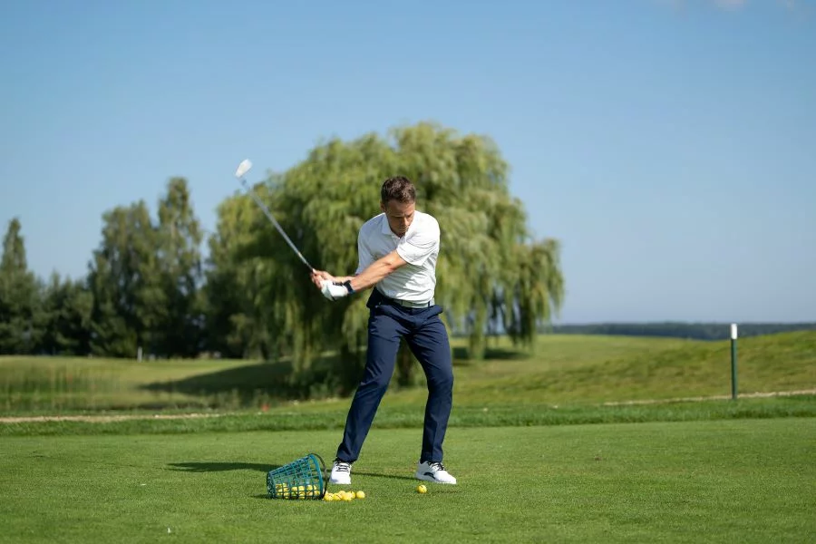 Golfer practicing wedges at driving range